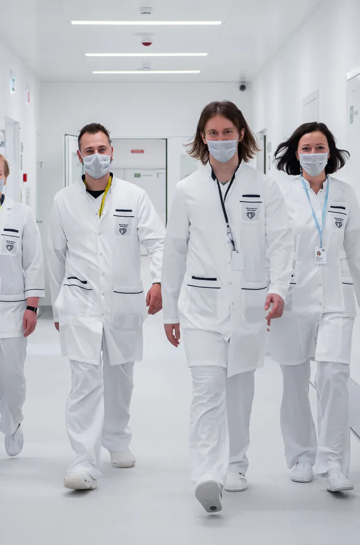 Médecins en blouse blanche qui avancent d'un pas décidé dans un couloir d'hôpital